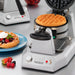 Waring WW200 double Belgian waffle maker with a golden waffle and a plated waffle topped with berries