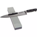 Winco combination sharpening stone with fine/medium grain shown in use with a black-handled chef's knife