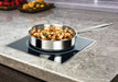 Winco EIDS-18C/EIDS-34 drop-in induction cooker installed flush in a granite countertop with a sauté pan of food