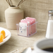 Winco clear plastic sugar packet holder filled with sweetener packets on a cafe table setting, shown in use