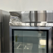 Scratch and dent Nordic Air SGR-48C refrigerator, close-up of the top header with the Nordic Air logo above a glass door