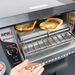APW Wyott AT Express conveyor toaster, close-up of a hand pulling out the front tray of finished toast