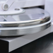 Alpha ADP-18-240 manual pizza dough press, close-up of the edge of the stainless steel heated pressing platens