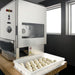 BakeMax BMDD003 countertop dough divider and rounder shown in a kitchen setting beside a tray of portioned dough balls