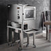 BakeMax BMDD005 countertop dough divider and rounder on a stainless steel stand with casters, shown in a bakery setting