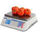 Detecto D Series price computing scale weighing tomatoes on the stainless steel tray, white body with LCD display