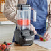 Hamilton Beach HBB255 Rio commercial drink blender in use blending strawberries on a kitchen counter