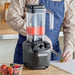 Hamilton Beach HBH455 Tango commercial blender in use blending strawberries on a kitchen prep counter