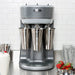 Hamilton Beach HMD400 triple-spindle drink mixer on a counter mixing three milkshakes in stainless steel cups