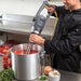 Hamilton Beach HMI series commercial immersion blender in use by a chef pureeing tomato soup in a large stock pot