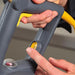 Hamilton Beach HMI series immersion blender, close-up of hands on the grey handle with the yellow trigger switch