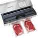 Hamilton Beach HVS400R out of chamber vacuum sealer with lid open, shown with two vacuum-sealed steaks