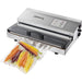 Hamilton Beach HVS400R out of chamber vacuum sealer in stainless steel shown with a sealed bag of carrots