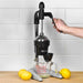 Hamilton Beach model 932 manual juicer shown in use pressing lemons into a glass measuring cup on a counter