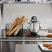 KitchenAid KSMC895OB 8 quart black commercial stand mixer in use on a stainless steel bakery counter