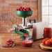 LEM 1227 Big Bite juicer attachment mounted on a grinder, pressing tomatoes into sauce on a kitchen counter