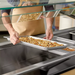 Phoenix STP24 series anti-jam steam table pan shown in use, shallow pan of roasted food set into a hot well