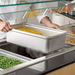 Phoenix STP24 series anti-jam steam table pan in use, deep pan of corn lifted from a buffet steam table