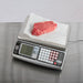 San Jamar Escali SCDG30LFT stainless steel price computing scale in use weighing a raw steak on deli paper