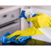 Winco 28 oz plastic spray bottle shown in use, gloved hands spraying and wiping a kitchen counter