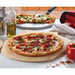 Winco 36 inch long wood pizza peel shown in use serving a baked pizza on a kitchen counter