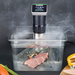 Winco ESVI-1 Spectrum 900W immersion circulator in use, clipped to a clear water bath cooking vacuum-sealed steak