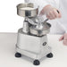 Winco KATTEX HBP-3 burger patty press in use, pulling down the lever handle to press the patty, side angle